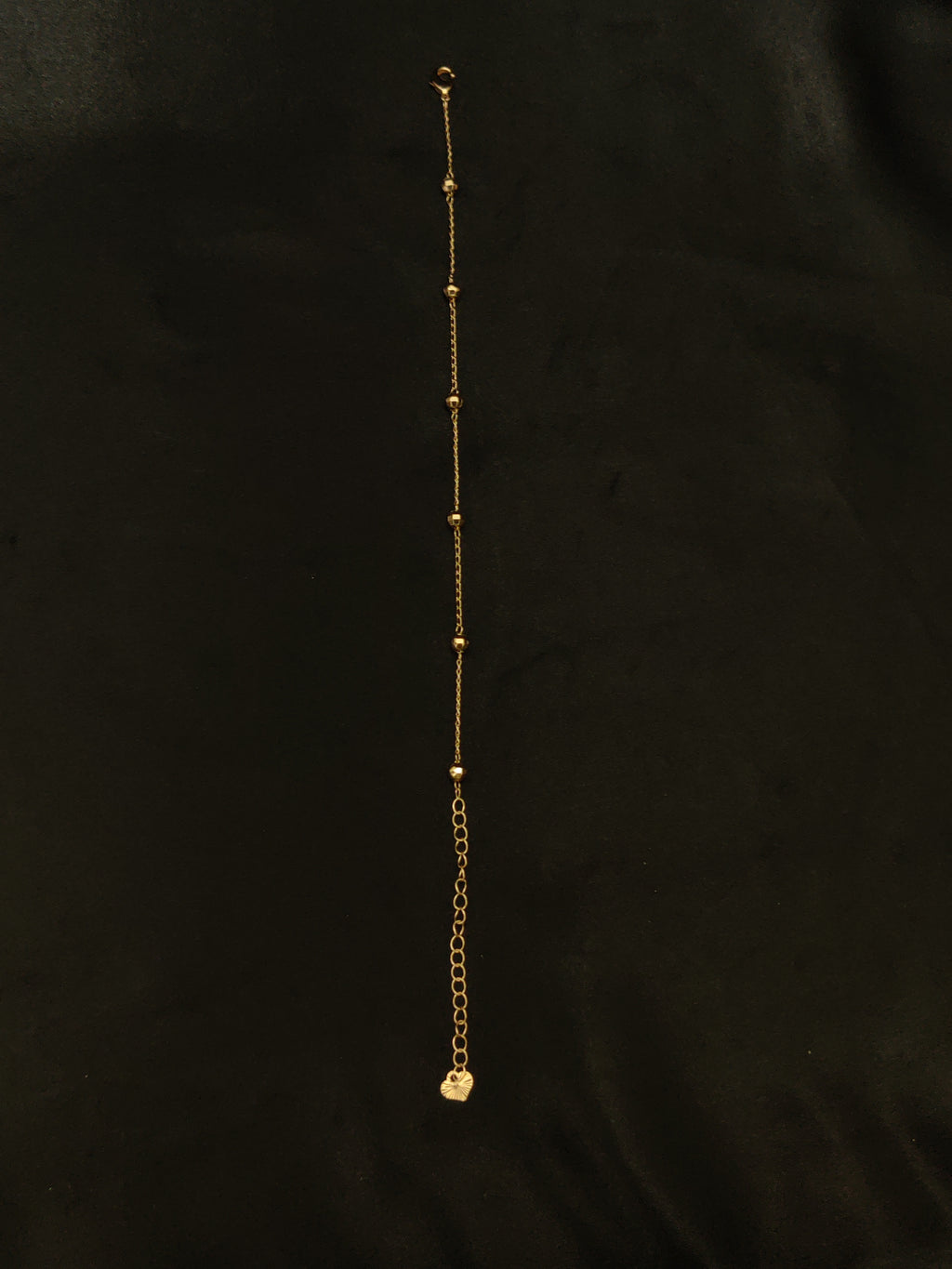 Gold chain bracelet on a black background